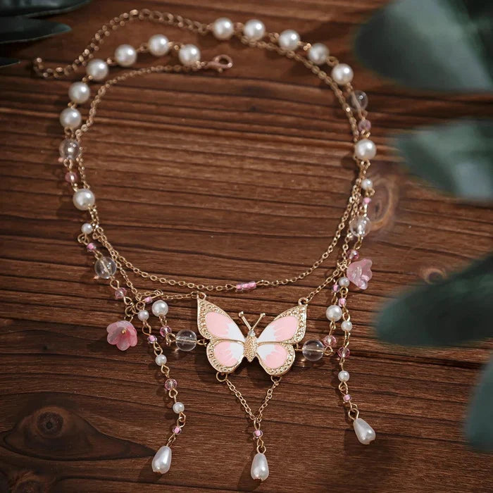 Gold multi-layer pearl necklace with pink butterfly pendant and dangling pearl and pink charms