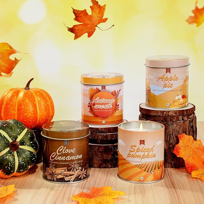 Assorted fall scented candle tins: Spiced pumpkin, Apple pie, Clove cinnamon, Autumn wreath, with pumpkins
