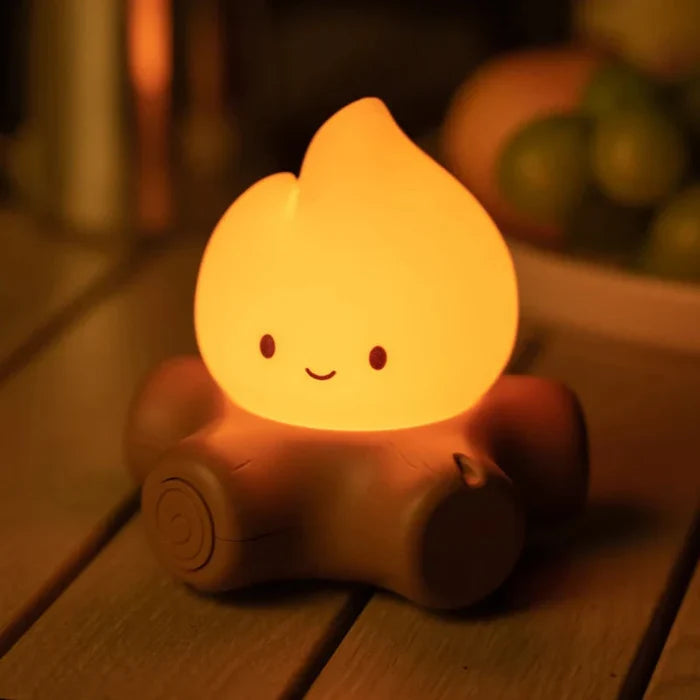 Glowing teardrop night light with smiling face on brown cushion base