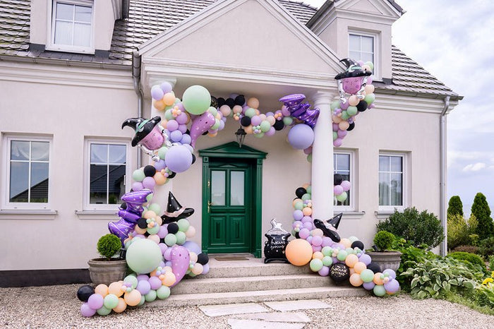 Pastel balloon arch with clusters and bat-themed balloon centerpiece