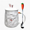 White ceramic bunny mug with rabbit saying 'Ha! Ha! Ha!' and carrot-handled spoon.