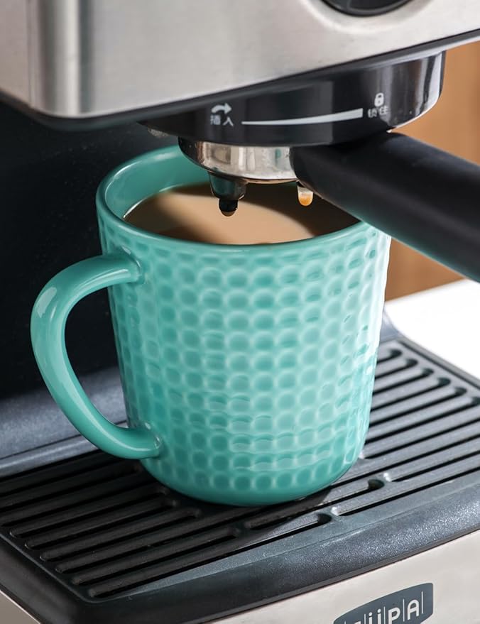 Turquoise waffle-embossed ceramic coffee mug with handle beneath espresso machine