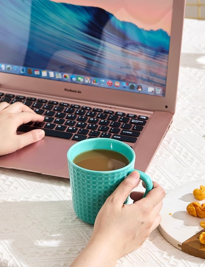 Turquoise waffle-embossed ceramic mug held in hand on desk