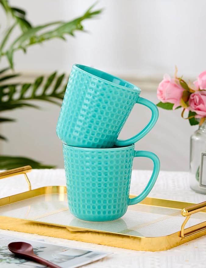 Turquoise waffle-embossed ceramic coffee mugs stacked with curved handles