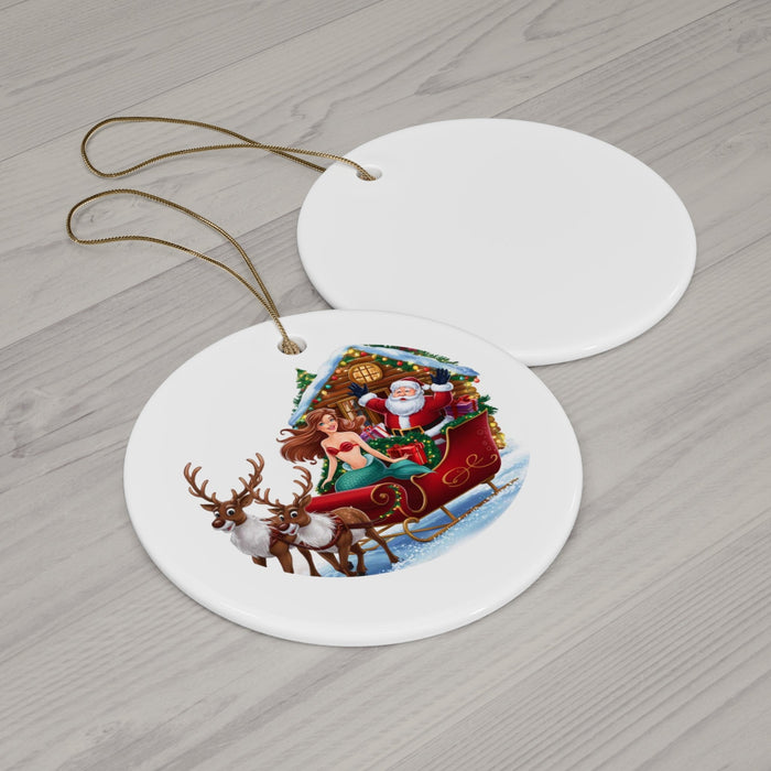 Two round ceramic ornaments with mermaid-and-Santa sleigh scene on light wood with gold cords