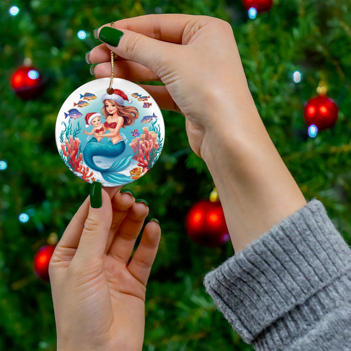 Handheld round ceramic ornament showing mermaid holding baby in blue ocean theme.