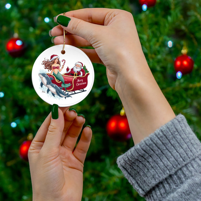 Round ceramic ornament with mermaid riding Santa’s sleigh with dolphins, gold hanging cord
