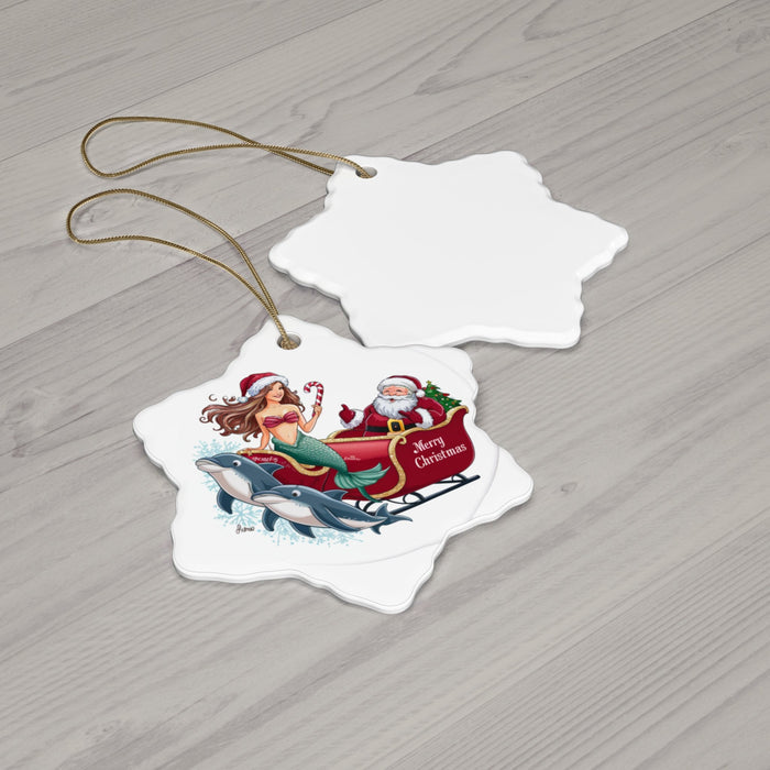 Two snowflake-shaped ceramic ornaments with mermaid and Santa riding dolphins; gold cords
