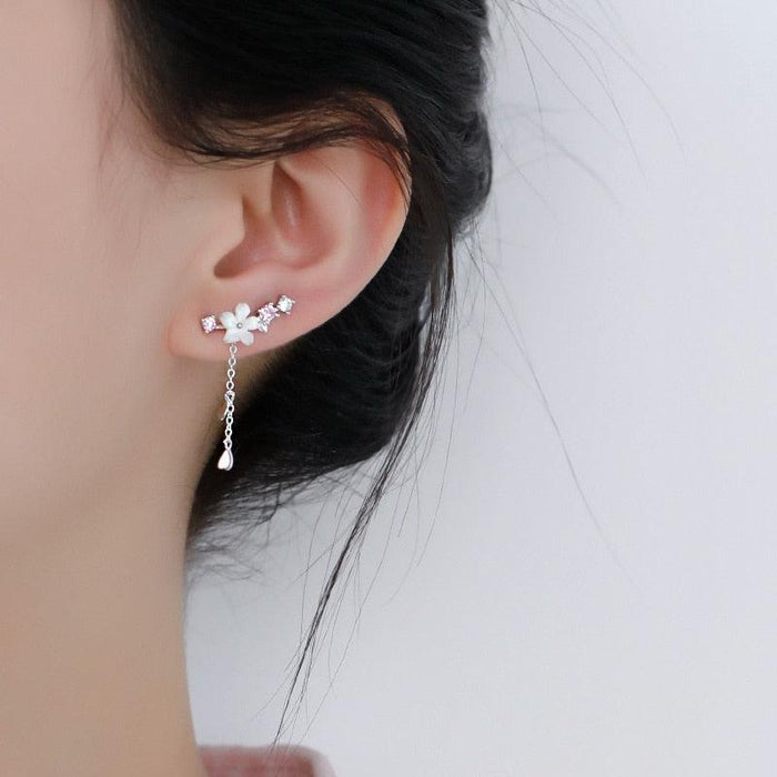 Cherry blossom drop earrings on ear, silver chain with pink flower clusters and heart charms