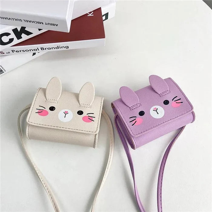 Beige and lavender bunny crossbody bags with stitched faces and shoulder straps
