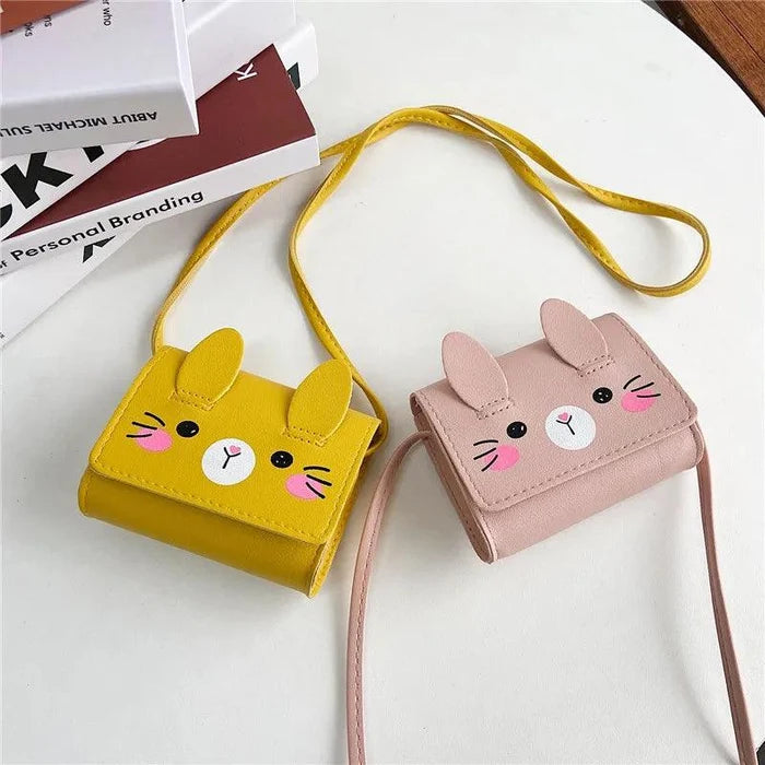 Yellow and blush pink bunny crossbody bags with stitched faces and adjustable strap