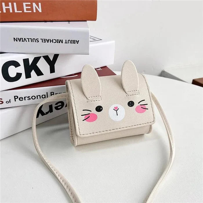 Beige bunny crossbody bag with stitched face, small flap, and long shoulder strap