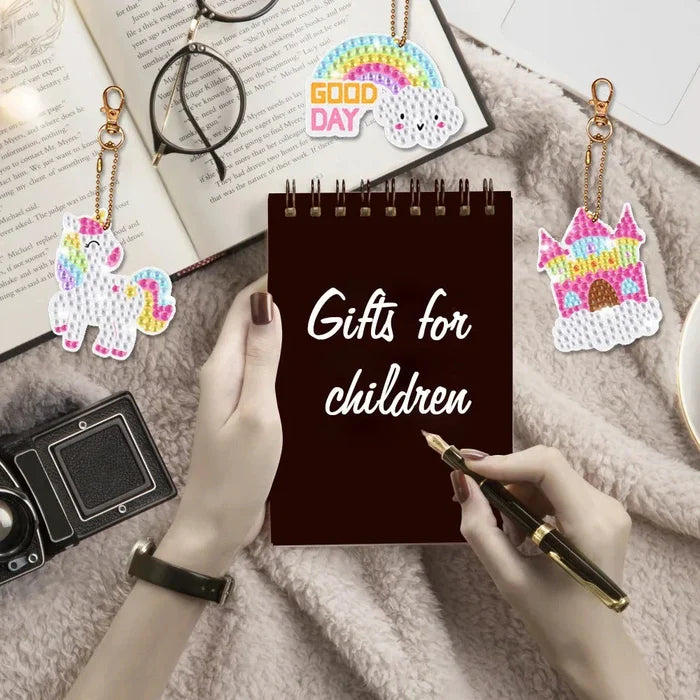 Children’s unicorn diamond painting keychain kit with multiple charm designs and tools.