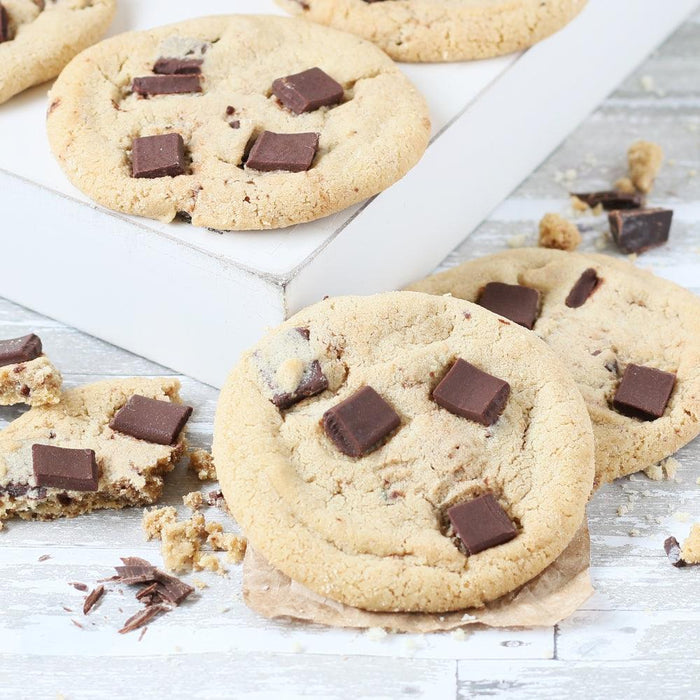 Chocolate chip cookies with visible chocolate chunks on parchment