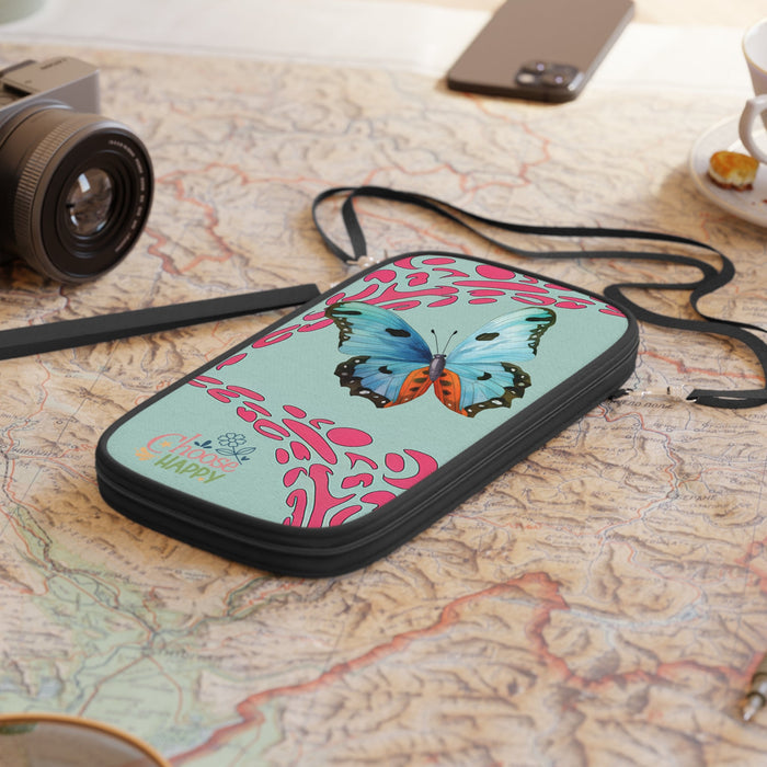 Mint passport wallet with butterfly and pink pattern, lying with black strap attached