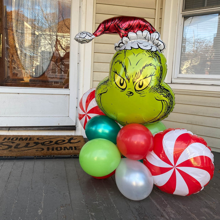 Grinch balloon head bouquet with red-and-white peppermint balloons and green latex accent balloons