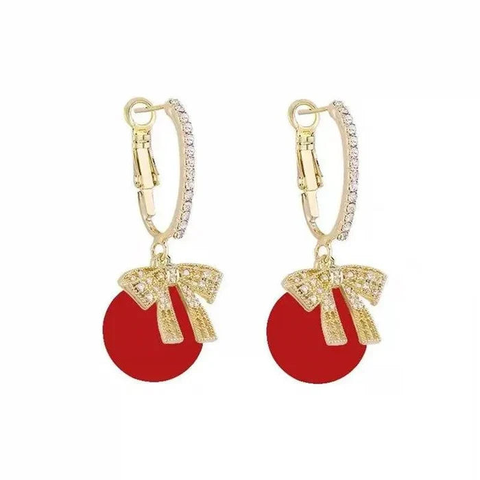 Hinged hoop earrings with red round ornament charms and rhinestone bow details