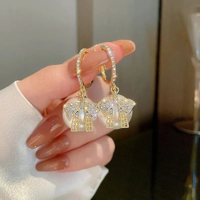 Gold hoop earrings with elephant charms and blue rhinestone accent details