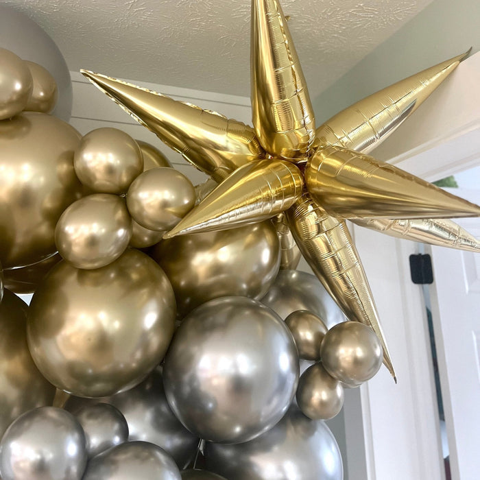 Close-up of gold and champagne balloon cluster with gold star topper