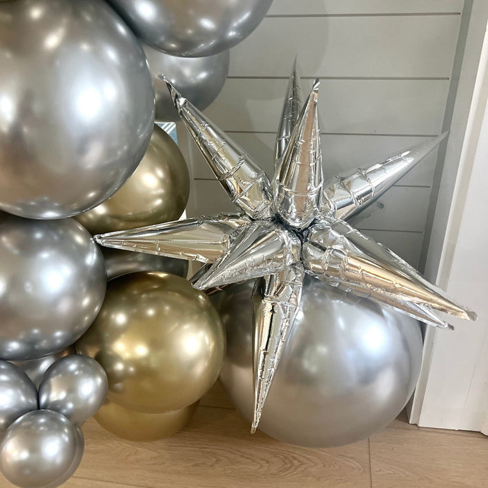 Close-up silver and gold balloon cluster with silver star topper