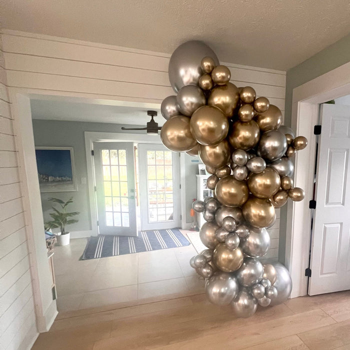 Silver and gold balloon arch with metallic clusters and star decorations