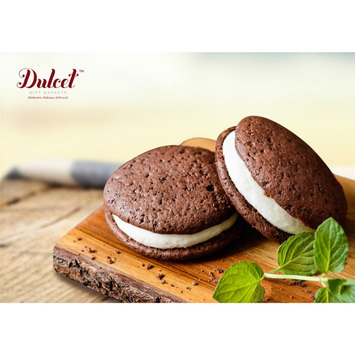 Chocolate sandwich cookies with white filling on a wooden board.