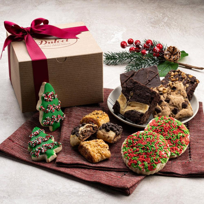 Holiday kraft gift box with ribbon, assorted cookies, and festive tree-shaped treats