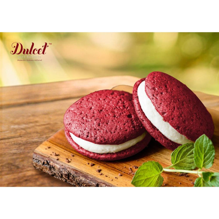 Red velvet sandwich cookies with white filling and fresh mint leaves