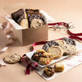 Assorted cookie gift box with ribbon, open cardboard tray of mixed sweets