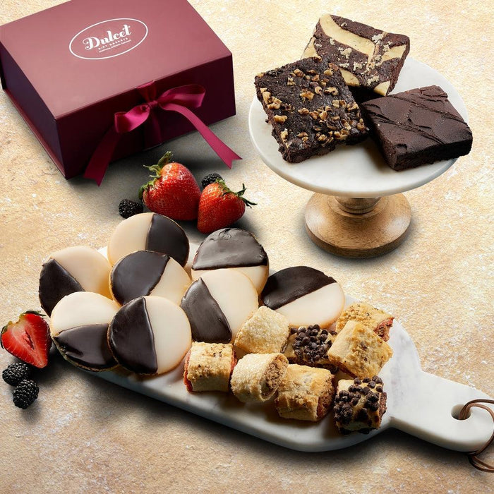 Red gift basket box with burgundy ribbon, with assorted chocolate desserts on a tray.