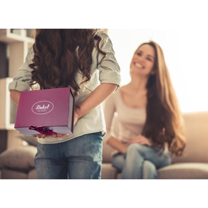 Valentines sweets gift basket in maroon box with ribbon, held by a person