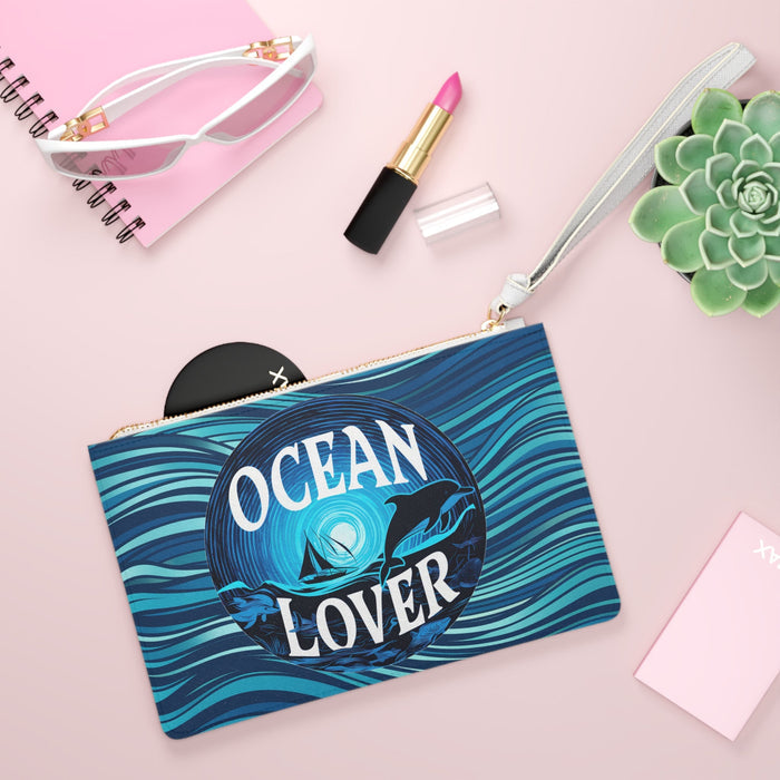 Ocean Lover clutch bag with blue wave print, round dolphin logo, white zip and strap
