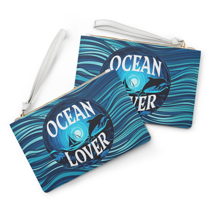 Two blue wave clutch bags with 'Ocean Lover' dolphin art, white straps and gold zippers