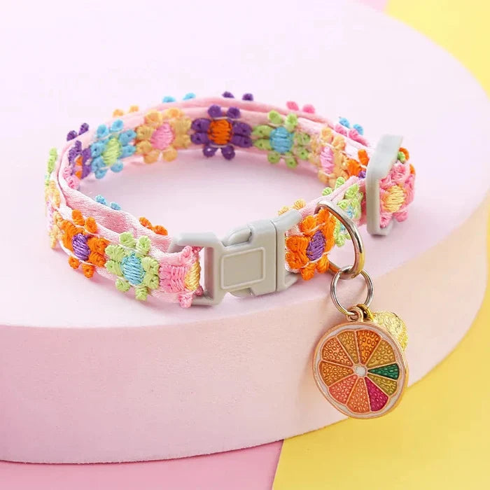 Adjustable braided pet collar, multicolor floral pattern, with bell and fruit charm.