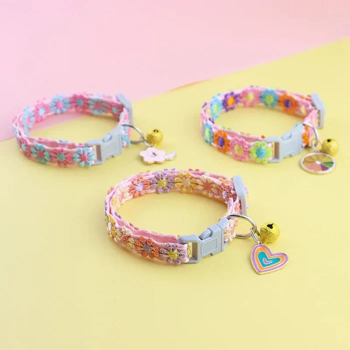 Adjustable pet collars with colorful woven trim, each with bell charm and clasp.