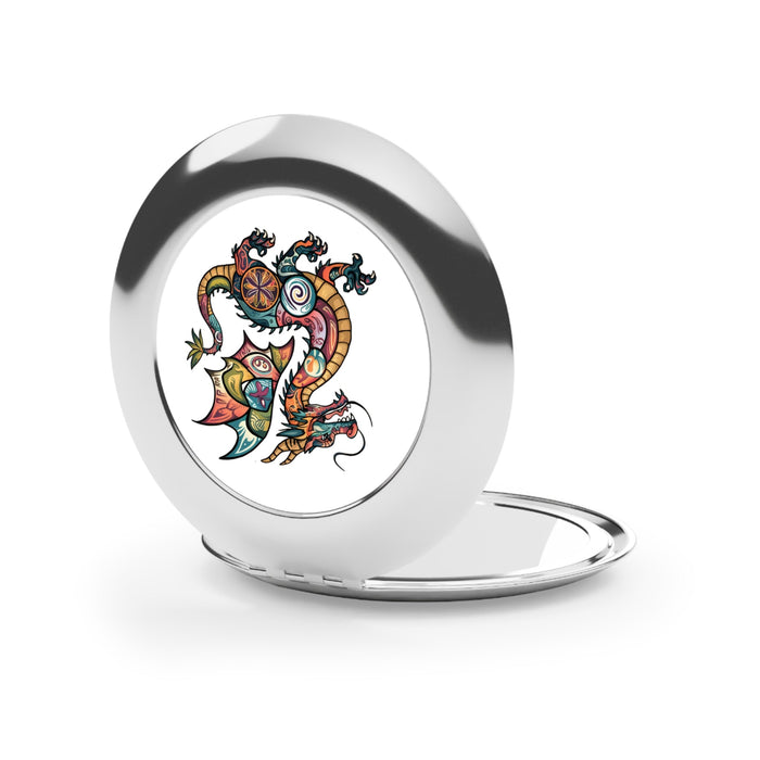 Silver glossy compact travel mirror open, showing dragon crest artwork