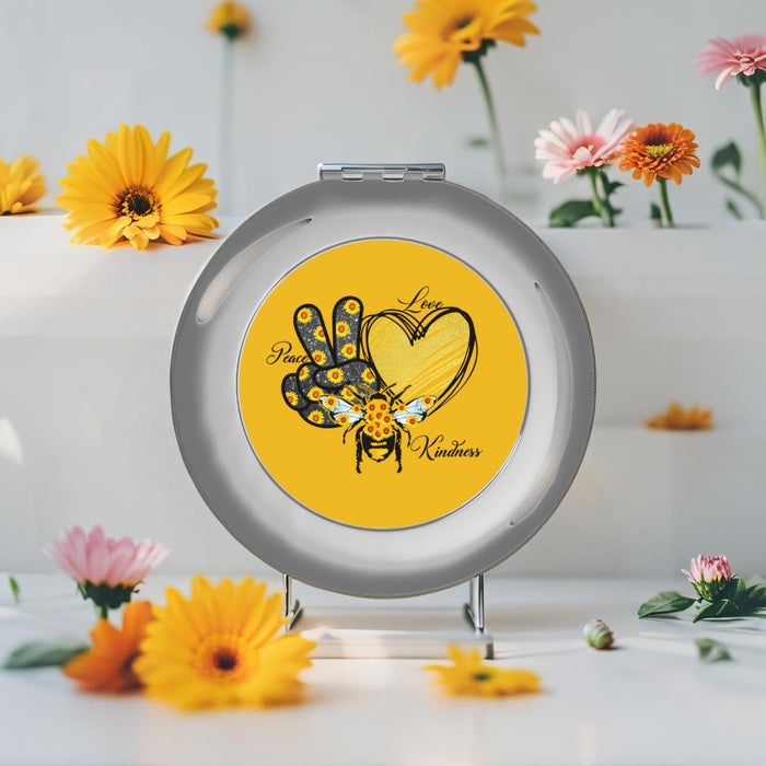 Silver glossy compact travel mirror, open circular frame with front artwork visible