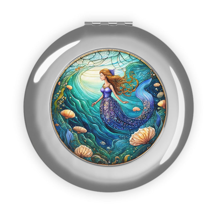Glossy silver compact travel mirror, round case with mermaid artwork on the face.