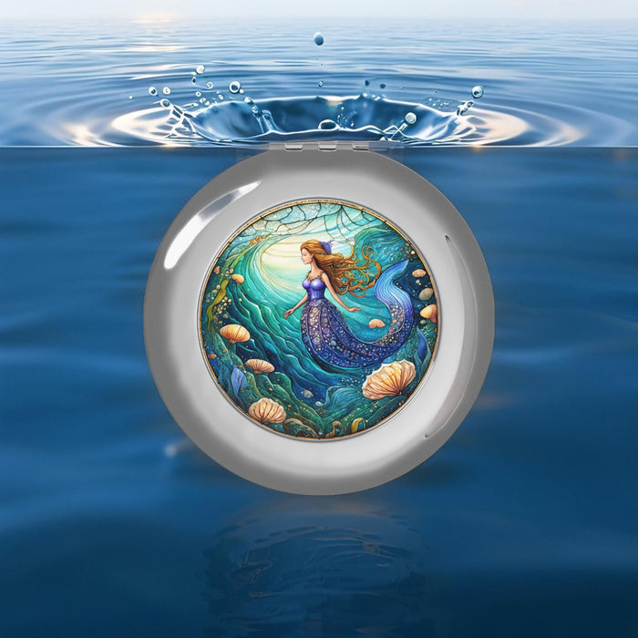 Glossy silver compact travel mirror with round mermaid artwork center and hinged lid.
