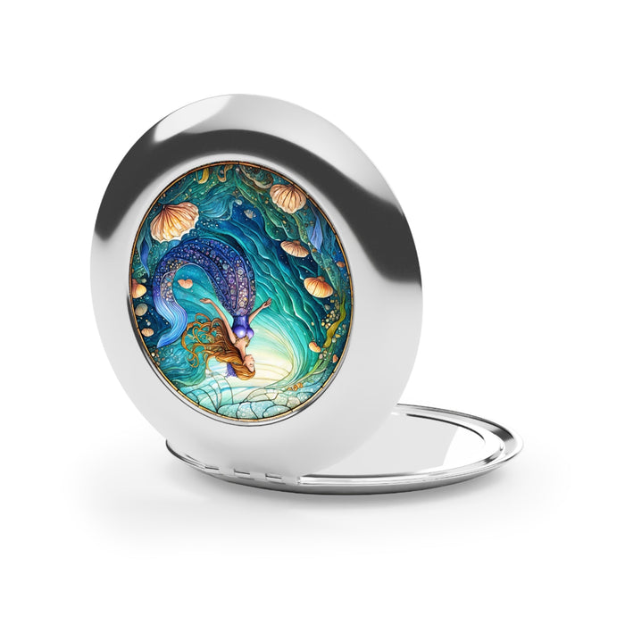 Glossy silver compact travel mirror with mermaid artwork on the front, lid closed.