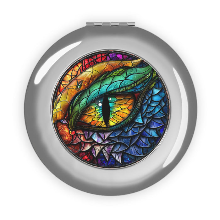 Silver compact travel mirror with dragon eye artwork, circular glossy case.