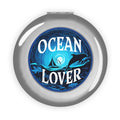 Silver round compact mirror with Ocean Lover ocean graphic and dolphins on the front
