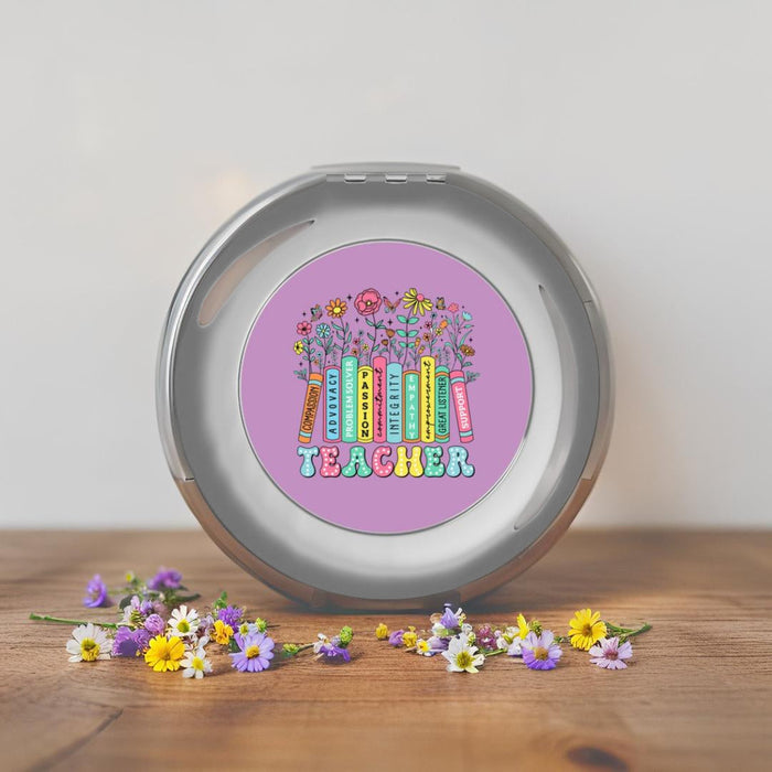 Silver compact travel mirror upright, showing a purple teacher-themed round design
