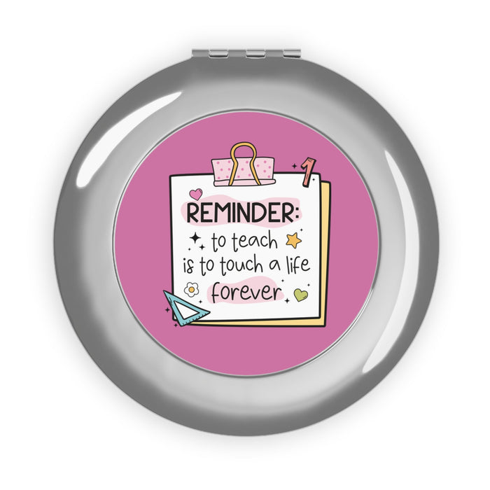 Silver glossy compact travel mirror with pink reminder insert under glass