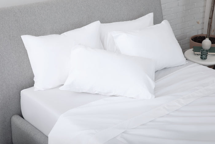 White pillows on a bed with a gray headboard