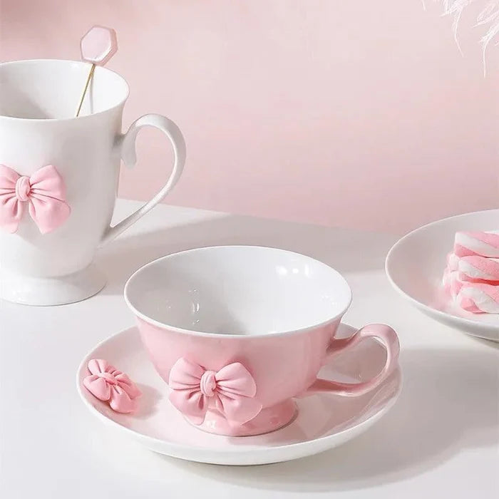 Pink tea cup with white body and pink bow detail on matching saucer