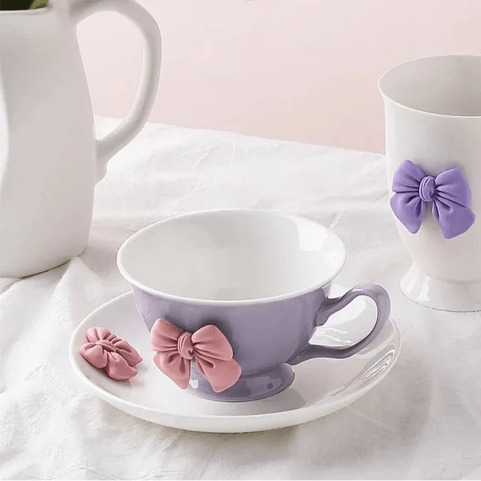 Lilac tea cup and saucer with purple bow decoration and curved handle