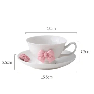 Tea cup and saucer dimensions diagram: white cup with pink bow, 13cm by 15.5cm