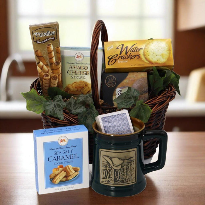 Gift basket with woven handle, dark mug, crackers and caramel cookie box, green leaf filler