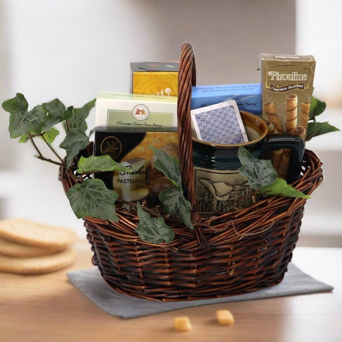 Gift basket with woven rim, dark mug, snack packages, and green leaf filler with tall handle